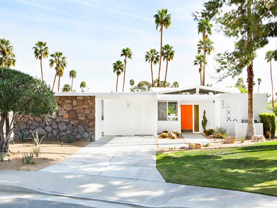 A mid century home with exterior paint colors of stark white and burnt orange.