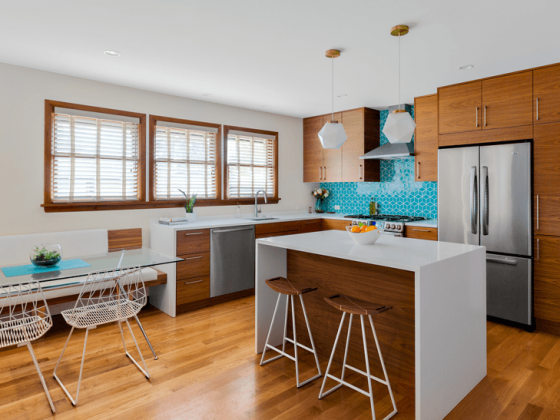 A mid century kitchen with a turquoise, geometric tile scheme.