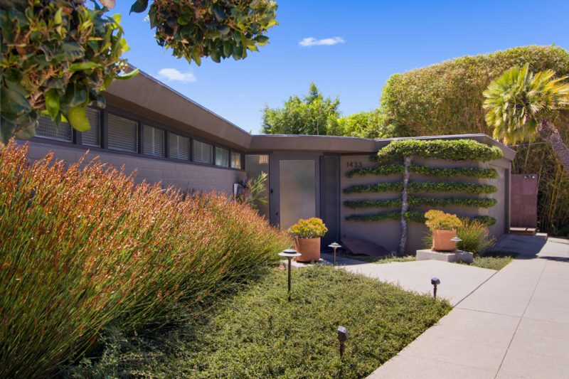 An oversized glass door leads to the entrance hall of this mid century San Diego home designed by Lloyd Ruocco.