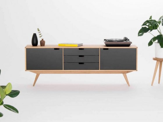 A mid century modern credenza with a solid wood enclosure and black drawer layout.