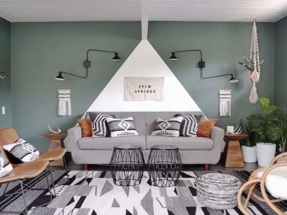 A mid century bungalow living room that features a geometrically-set rug, as well as a gray and teal color scheme.