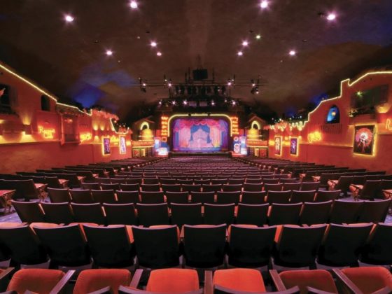 The plaza theatre interior detailing its red chairs and expansive hall.