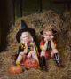 children wearing Halloween costumes sitting on hay