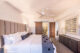 A bed with a white comforter, sheets, and pillows
