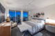 A bed with a white comforter, sheets, and pillows