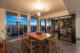 A vintage table in front of a wall of floor-to-ceiling windows