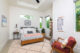 Guest bedroom with patterned bedspread and Eames chair