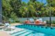 Poolside brick patio and pool with mid-century modern chairs