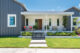 Curb shot of a modern home with gray siding and white front patio
