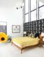 MCM guest bedroom with graphic wallpaper platform bed yellow accents