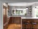 renovated MCM kitchen with globe pendant lights, large island, wood cabinetry