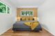 wallpapered accent wall in MCM bedroom with 70s gold and yellow geometric pattern