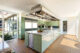 kitchen with wall of window, green cabinets and large island