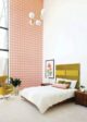 guest bedroom with green Arne Jacobsen egg chair colorful pink and coral wallpaper and chartreuse fabric headboard